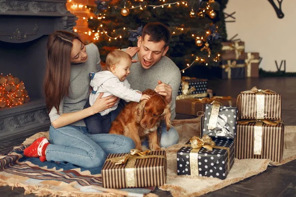 Familia con lindo perro en casa cerca del árbol de Navidad — Foto de Stock