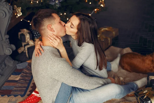 Elegante pareja en casa cerca del árbol de Navidad —  Fotos de Stock