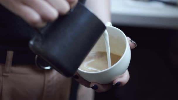 Barista häller mjölk i en kopp kaffe — Stockvideo