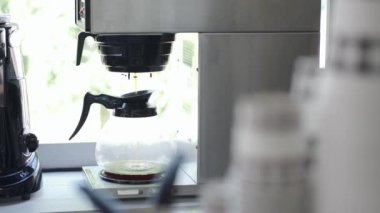 Kahve makinesinden çaydanlığa dökülen kahvenin yakın görüntüsü