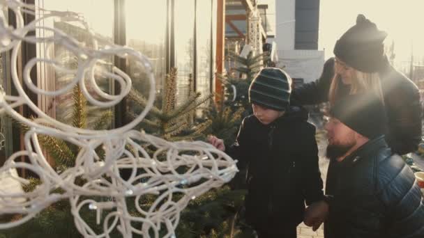 Rodiče s malým synem vybírat cristmas strom na trhu — Stock video
