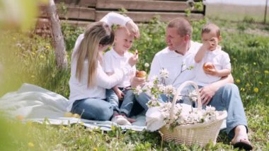 İki küçük oğlu olan ebeveynler köyde piknik yapıyorlar.