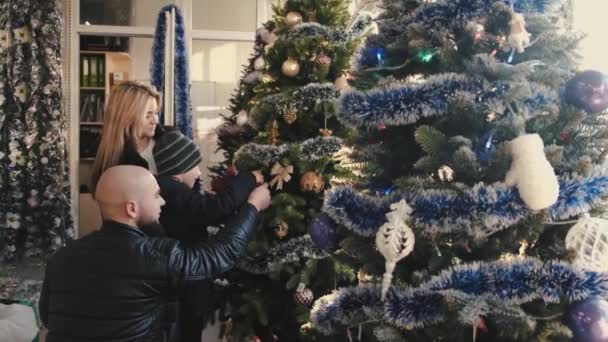 Madre y padre comprando adornos de cristmas con su hijito — Vídeos de Stock