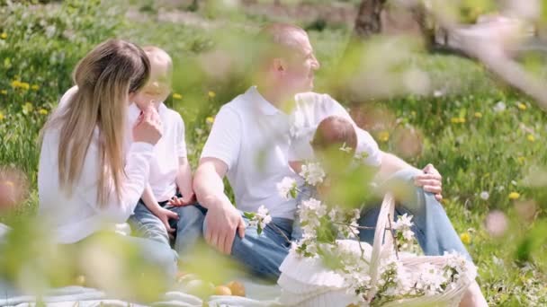 Ouders met twee zoons picknicken in het dorp — Stockvideo