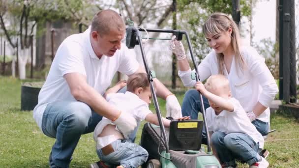 Köyde çim biçme makinesi ve çim biçme makinesi kullanan aile. — Stok video