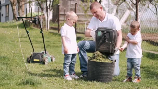 Ayah mengajar dua anak kecil berkebun di desa — Stok Video