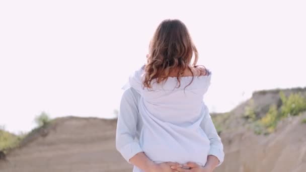 Парень держит девушку во время свидания в карьере — стоковое видео
