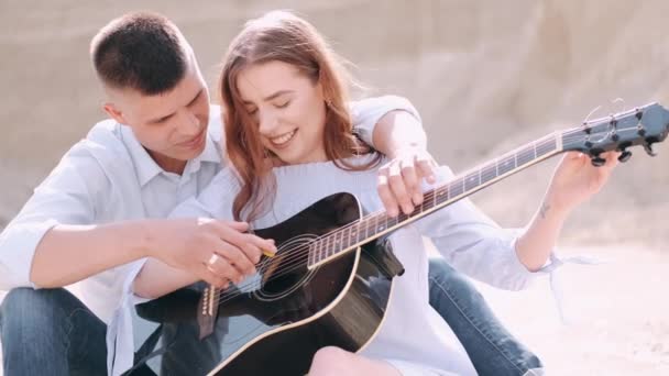 Přítel učí přítelkyni, jak hrát píseň v kariéře — Stock video
