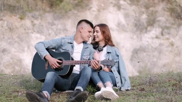 Man plays song for girlfriend on romantic date in forest — Stock Video