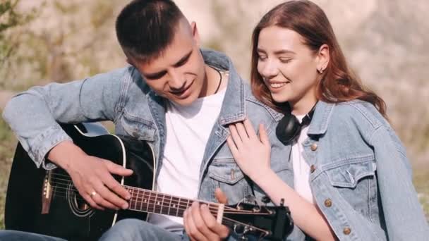 Muž hraje píseň pro přítelkyni na romantické rande v lese — Stock video