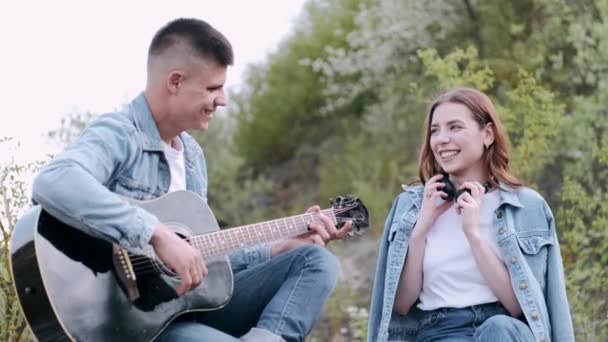 Homem toca música para namorada em encontro romântico na floresta — Vídeo de Stock