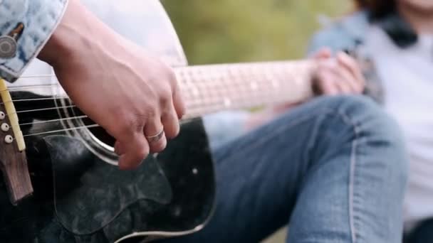 Detailní záběr mužské ruky hrát píseň pro přítelkyni na rande — Stock video
