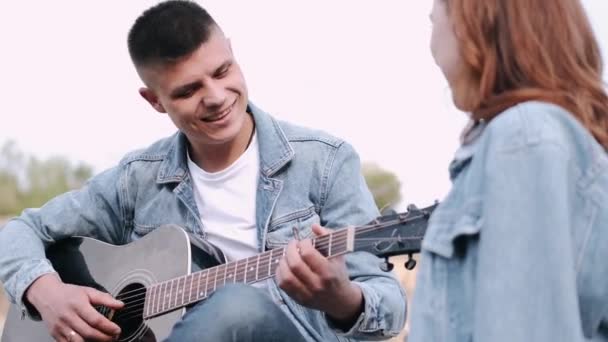 Homem toca música para namorada em encontro romântico na floresta — Vídeo de Stock