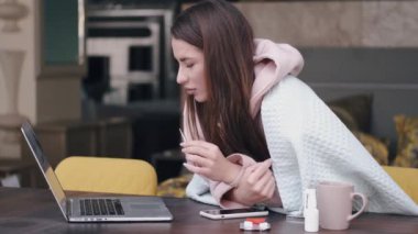 Elinde termometresi olan genç bir kadın internetteki ihlali araştırıyor.