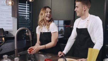 Mutfakta sebze yıkayan bir çift.