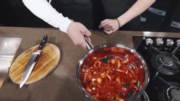 Portret van een koppel dat samen een groente bereidt in de keuken — Stockvideo