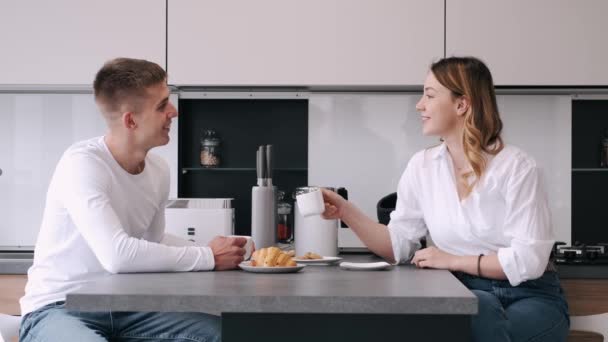 Uśmiechnięta para pijąca kawę w kuchni w domu — Wideo stockowe