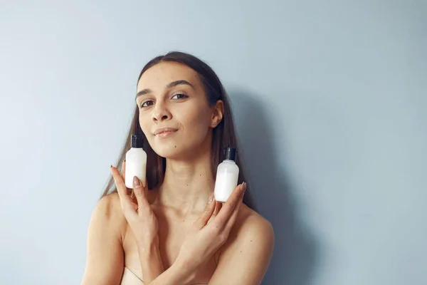 Mooi meisje staan in een studio met crème — Stockfoto