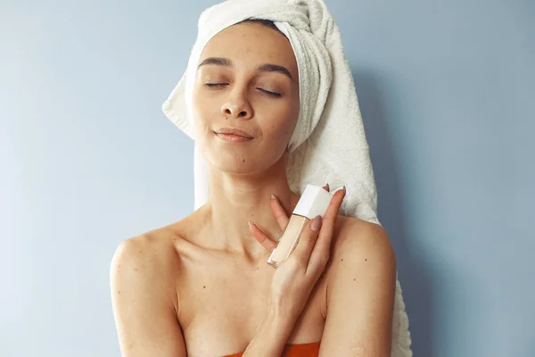 Mooi meisje staan in een studio met crème — Stockfoto