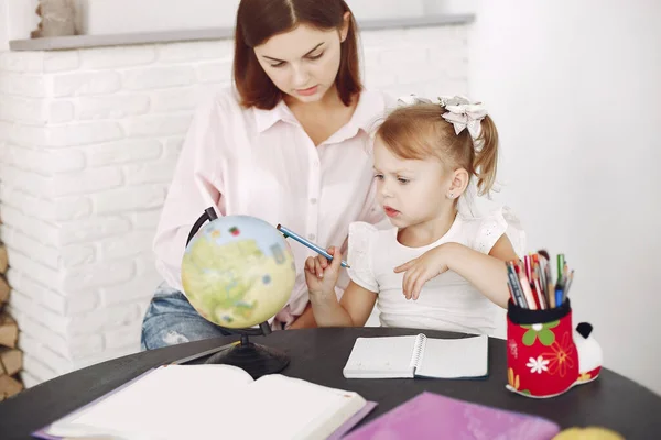 Tutor with litthe girl studying at home Stock Photo