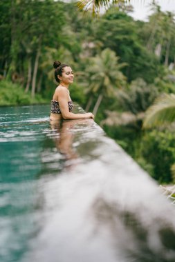 Orman manzaralı havuzda bir kadın.