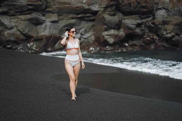Flicka i en snygg baddräkt har en vila n en strand — Stockfoto