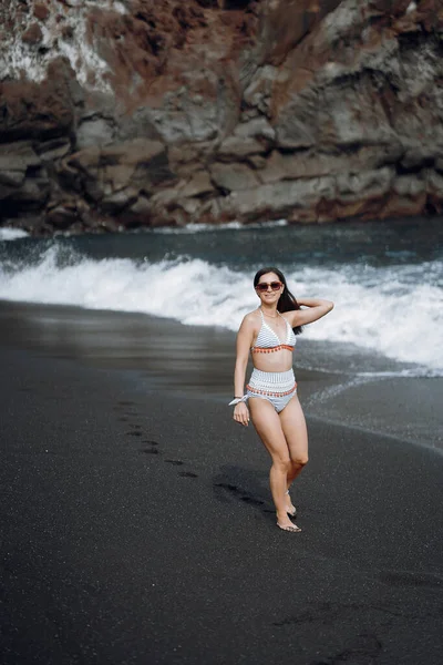 La ragazza in un costume da bagno elegante ha un riposo n una spiaggia — Foto Stock