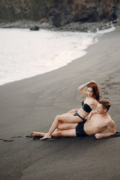 Elegante pareja en una playa cerca de las rocas —  Fotos de Stock