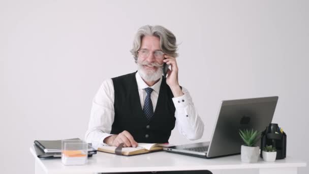 Viejo hombre de negocios con estilo hablando por teléfono en la oficina — Vídeo de stock
