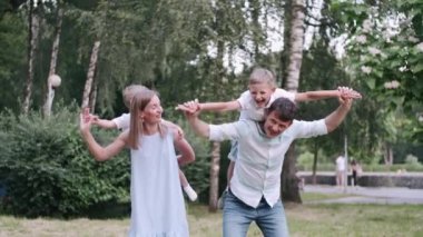 Mutlu ebeveynler ve küçük oğullar dışarıda eğleniyorlar.
