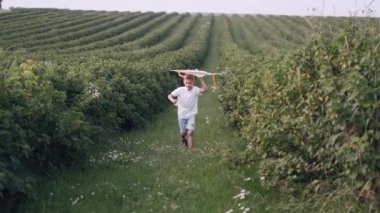 Bir çocuk yeşil alanda uçurtma uçuruyor.