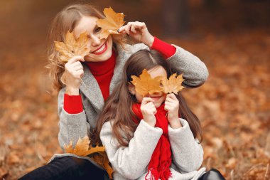 Sonbahar parkında şirin ve şık bir aile.