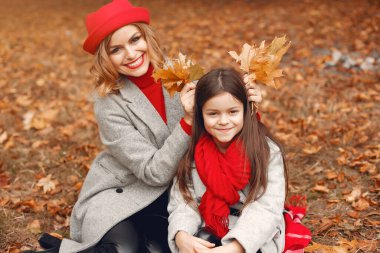 Sonbahar parkında şirin ve şık bir aile.
