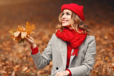 Güz parkında oturan güzel bir kadın