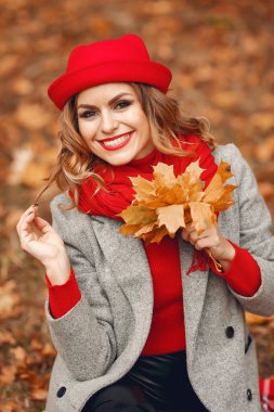 Güz parkında oturan güzel bir kadın