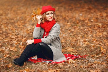 Güz parkında oturan güzel bir kadın