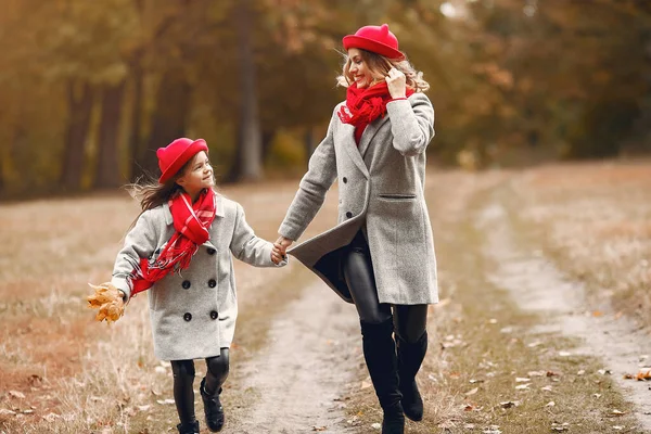 Sonbahar parkında şirin ve şık bir aile.