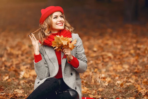 Mulher bonita sentada em um parque de outono — Fotografia de Stock