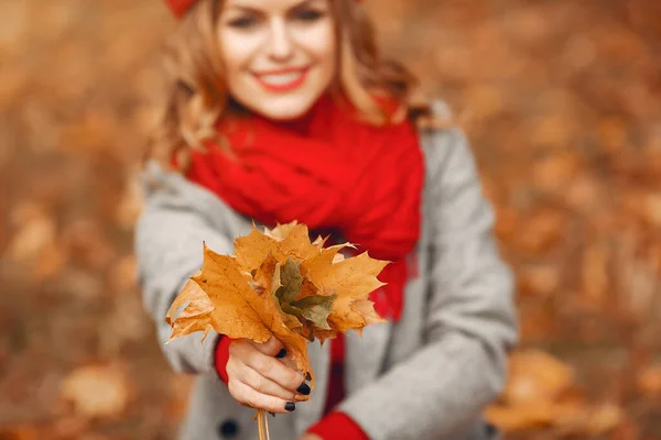 Beautiful woman sitting in a autumn park — Stock Photo, Image