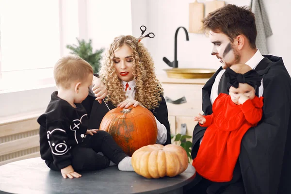 Familia en disfraces preparándose para Halloween en casa — Foto de Stock