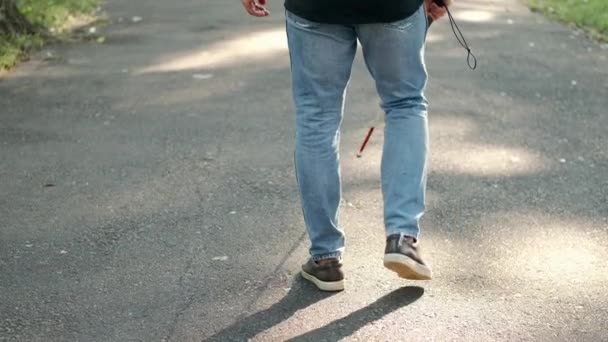 Молодий сліпий чоловік ходить в парку — стокове відео