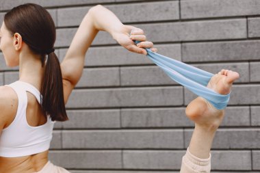Karanlık bir şehir duvarına karşı gelişmiş yoga yapan bir kadın.