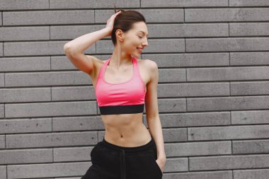 Karanlık bir şehir duvarına karşı gelişmiş yoga yapan bir kadın.