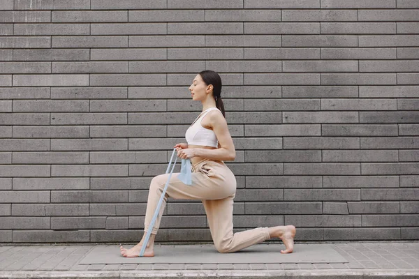 Жінка практикує просунуту йогу проти темної міської стіни — стокове фото