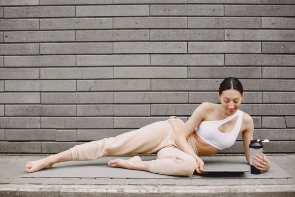 Mujer practicando yoga avanzado contra un muro urbano oscuro — Foto de Stock