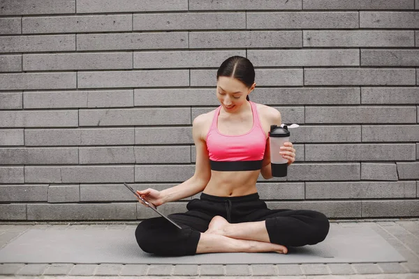 Kvinna som utövar avancerad yoga mot en mörk urban vägg — Stockfoto