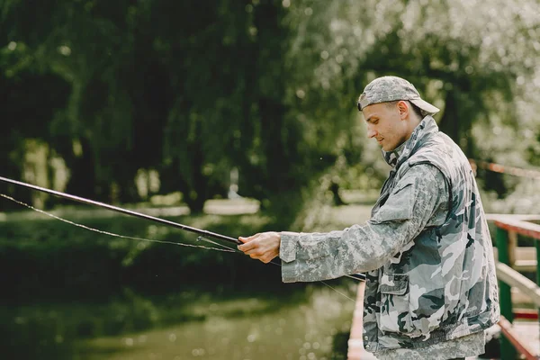 Uomo pesca e tiene la canna da pesca — Foto Stock