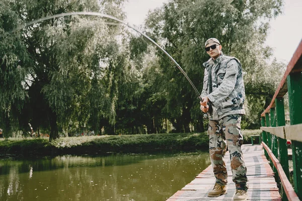 男人钓鱼，拿着钓竿 — 图库照片
