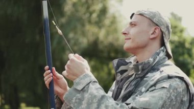 Adam göl kıyısındaki bir çubuğa iplik geriyor.