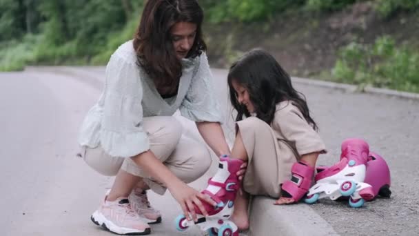 Mooie moeder en kind in rolschaatsen op de weg — Stockvideo